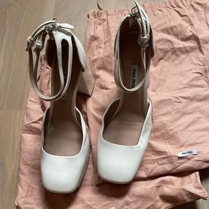 White patent leather pumps by Miu Miu